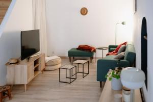 a living room with two green couches and a television at Villa Balma in Beaumes-de-Venise