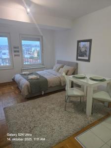 a bedroom with a bed and a desk and a table at Apartman 13 Valjevo in Valjevo