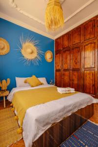 a bedroom with a large bed with a blue wall at Freebird Surfcamp Morocco in Agadir