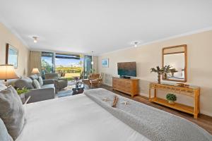 - un salon avec un grand lit et une télévision dans l'établissement Eldorado A107 · EL A107 Remodeled Studio, Golf Course, Beach!, à Kahana
