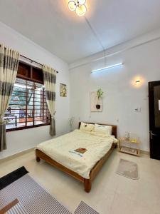 a bedroom with a large bed and a window at Sim House in Hue +13 photos