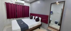 a small bedroom with a bed and a mirror at Collection O Paithan Gate Formerly Rajlaxmi Executive in Aurangabad