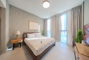 une chambre avec un lit et une grande fenêtre dans l'établissement Private Luxury Studio Apartment in AlJada by Arada, à Charjah 15 autres photos