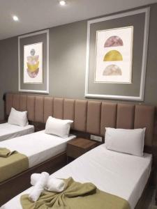 a room with two beds and two paintings on the wall at Residance touristique marcadal by mon rêve in Fort de lʼEau
