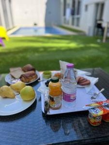 a table with plates of food and a bottle of juice at Residance touristique marcadal by mon rêve in Fort de lʼEau +10 photos