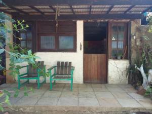 two chairs sitting outside of a house with a door at Hostel Kay Pacha e Camping in Maceió +7 photos