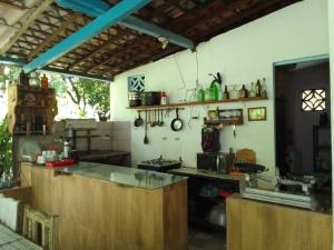 a large kitchen with wooden cabinets and a counter at Hostel Kay Pacha e Camping in Maceió