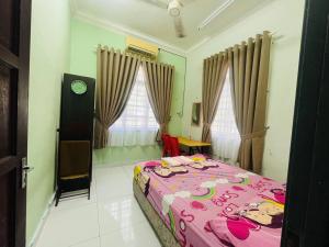 a bedroom with a pink bed with a hello kitty blanket at Villa Axalea Kuala Terengganu in Kuala Terengganu