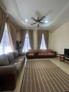 a living room with a couch and a ceiling fan at Villa Axalea Kuala Terengganu in Kuala Terengganu