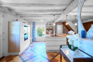 a kitchen with white cabinets and a blue tile floor at Gite La Périgourdine in Saint-Laurent-des-Hommes