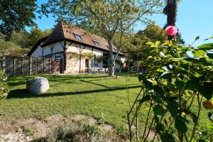 a house with a green yard with a flower at Gite La Périgourdine in Saint-Laurent-des-Hommes