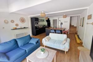 Una sala de estar con un sofá azul y una mesa. en Duplex House With Large Terrace And Garden, en Moliets-et-Maa