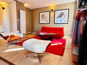 a living room with a red couch and chairs at La Petite Adresse du 10Honfleur in Honfleur