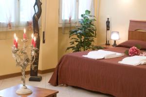 een slaapkamer met 2 bedden en 2 kaarsen op een tafel bij Argentiere Room Apartments in Florence