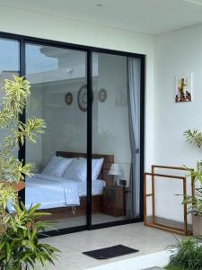 a bedroom with a bed and sliding glass doors at Famiglie Guest House in Canggu +12 photos