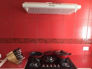 a red kitchen with two pots and pans on a stove at Villa del Mar in Costa Esmeralda