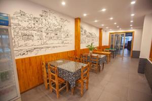 a restaurant with tables and chairs and a drawing on the wall at Yesuhanshe Homestay in Zhangjiajie