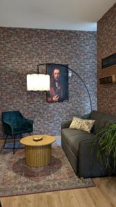 sala de estar con sofá y TV en una pared de ladrillo en Apartment - Dürer Blick, en Mühlhausen