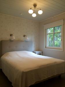 a bedroom with a large white bed with a window at Soukolo Apartments in Äkäslompolo