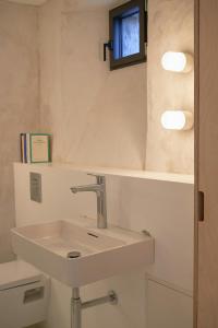 a bathroom with a white sink and a window at Restored Farm Near La Rochelle in La-Gripperie-Saint-Symphorien