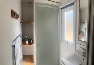 a bathroom with a shower and a sink and a window at Farniente en Cévennes in Génolhac