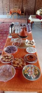 a long table with plates of food on it at Sahara Camp Excursions in Merdani