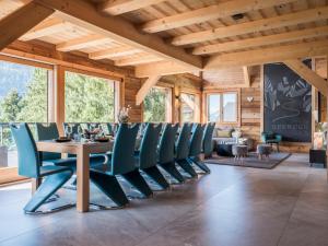 a dining room with a table and blue chairs at Chalet Familial Spacieux Le Spencer Grand Luxe Châtel in Châtel