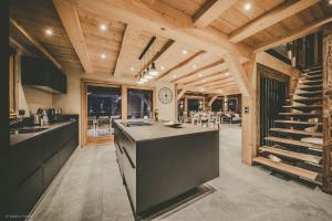 a large kitchen with a counter and a staircase at Chalet Familial Spacieux Le Spencer Grand Luxe Châtel in Châtel