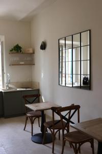 a kitchen with two tables and a mirror on the wall at Casa Zarinelli in Castagneto Carducci