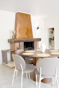 a dining room with a table and chairs and a fireplace at Docatange in Boisgasson
