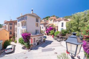 Una calle de un pueblo con casas y una farola. en Bright and confortable apartment in downtown BLM, en Bormes-les-Mimosas