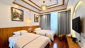 a hotel room with two beds and a flat screen tv at Yesuhanshe Homestay in Zhangjiajie