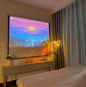 een slaapkamer met een groot raam en een grote televisie bij homestay vinhome smart city in Phú Thú