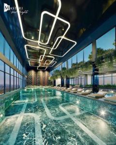 een groot zwembad in een gebouw met ramen bij homestay vinhome smart city in Phú Thú