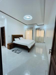 a white bedroom with a bed and a ceiling at Villa Serenite in Dakar