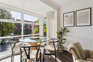 a dining room with a glass table and chairs at Elegant 1-Bed Flat with Parking & Long Walk Views in Windsor