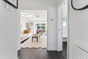 a white living room with a couch and a table at Elegant 1-Bed Flat with Parking & Long Walk Views in Windsor +1 photo