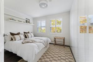 a white bedroom with a bed and a chair at Elegant 1-Bed Flat with Parking & Long Walk Views in Windsor