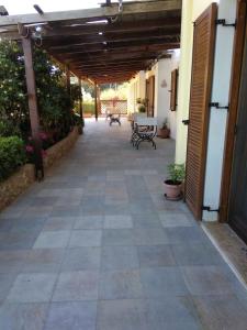 an outdoor patio with benches and a wooden pergola at Vromolithos apartments in Nisís Léros