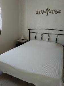 a bed in a bedroom with a white mattress at Vromolithos apartments in Nisís Léros