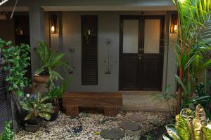 a house with a bench in front of a door at Baan Paea Guest House in Ban Ket Ho