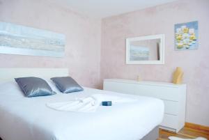 1 dormitorio con 1 cama blanca con 2 almohadas y espejo en La Milena, en Morancez 30 fotos más