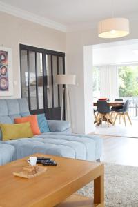 Una sala de estar con un sofá azul y una mesa. en La Milena, en Morancez
