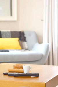 Un control remoto sobre una mesa con una taza de café. en La Milena, en Morancez