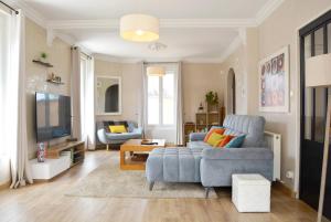 a living room with a blue couch and a tv at La Milena in Morancez