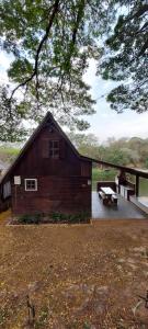 a wooden barn with a picnic table and a bench at Chale Recanto do Lago in Itu