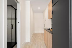 a kitchen with white walls and a glass door at Dobo Alcorcón VG29 in Alcorcón