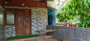 a house with a wooden door and a wooden bench at Sheshu Homestay in Māvalli +14 photos