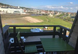 a balcony with a green bench and a view at Une escapade à l'estacade in Deauville
