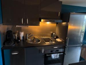 a kitchen with a sink and a refrigerator at Une escapade à l'estacade in Deauville